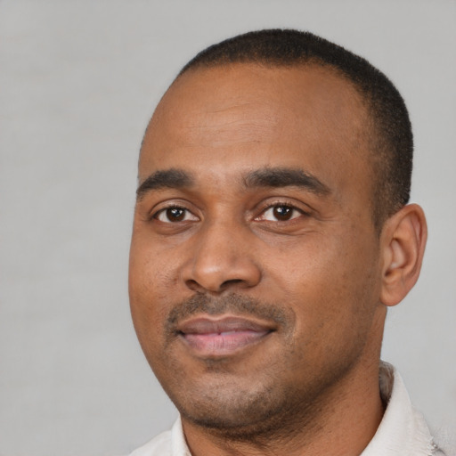 Joyful black young-adult male with short  black hair and brown eyes