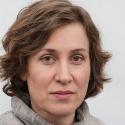 Joyful white adult female with medium  brown hair and grey eyes