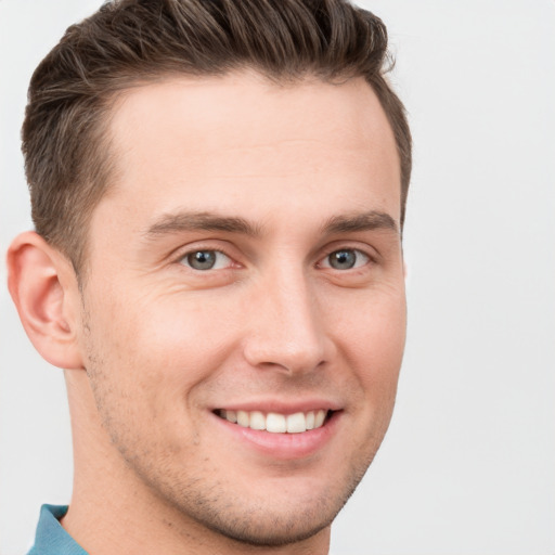 Joyful white young-adult male with short  brown hair and grey eyes