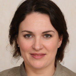 Joyful white adult female with medium  brown hair and green eyes