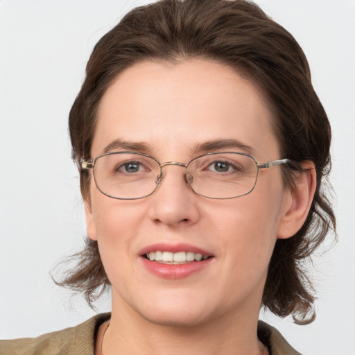 Joyful white adult female with medium  brown hair and grey eyes