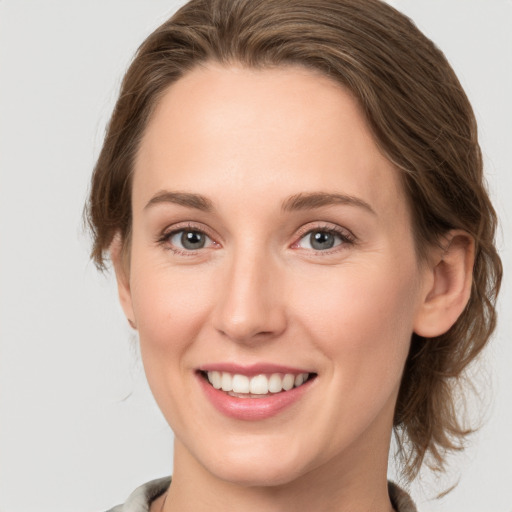 Joyful white young-adult female with medium  brown hair and grey eyes