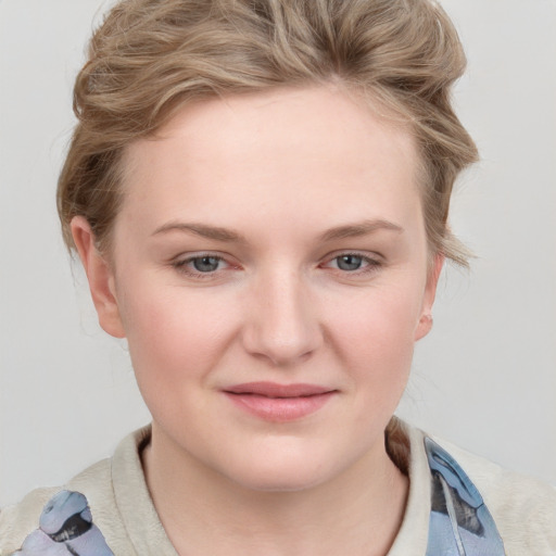 Joyful white young-adult female with short  brown hair and blue eyes