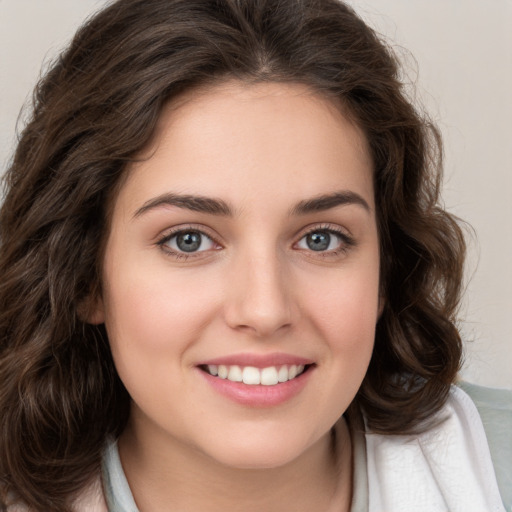 Joyful white young-adult female with medium  brown hair and green eyes