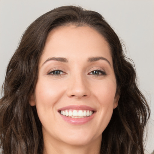 Joyful white young-adult female with long  brown hair and brown eyes