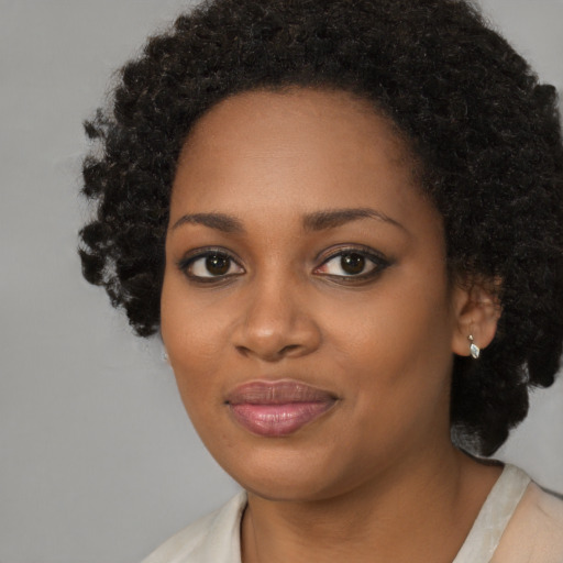 Joyful black young-adult female with short  black hair and brown eyes