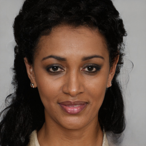 Joyful black young-adult female with long  black hair and brown eyes