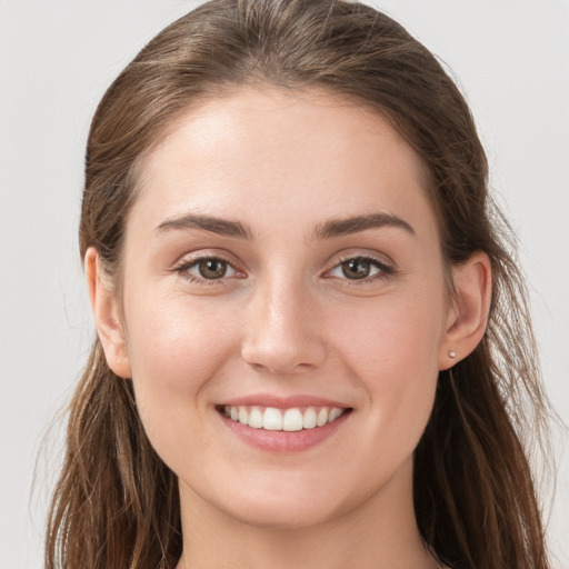 Joyful white young-adult female with long  brown hair and grey eyes