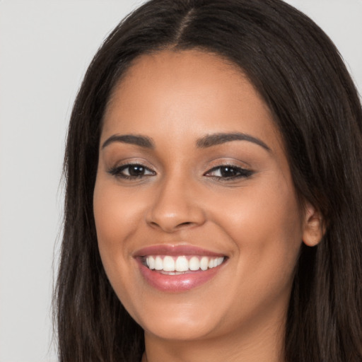 Joyful latino young-adult female with long  brown hair and brown eyes