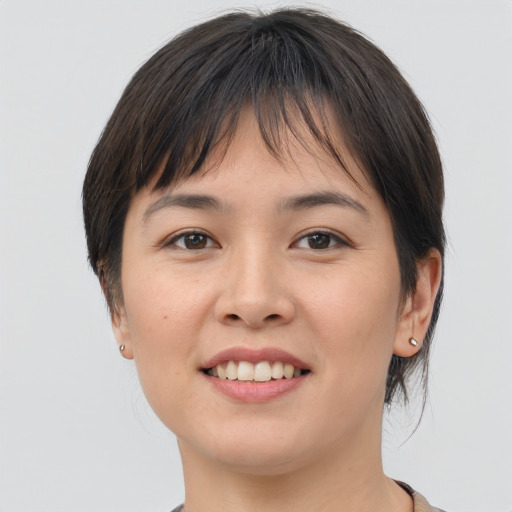 Joyful asian young-adult female with medium  brown hair and brown eyes