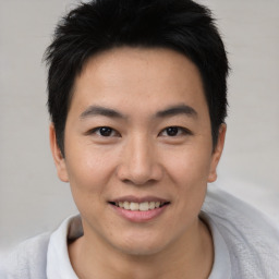 Joyful asian young-adult male with short  brown hair and brown eyes