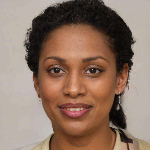 Joyful black young-adult female with short  brown hair and brown eyes