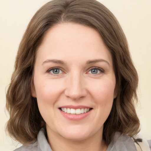 Joyful white young-adult female with medium  brown hair and green eyes