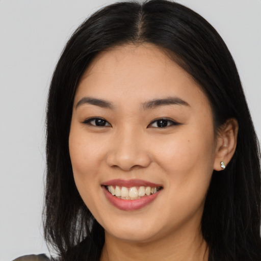 Joyful asian young-adult female with long  brown hair and brown eyes