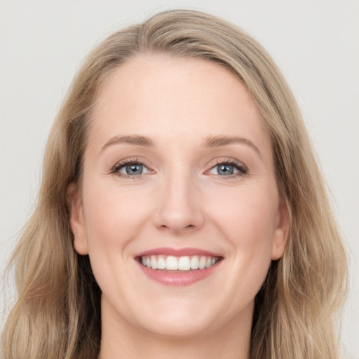 Joyful white young-adult female with long  brown hair and blue eyes