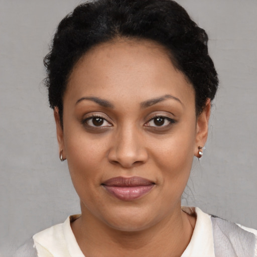 Joyful black young-adult female with short  black hair and brown eyes