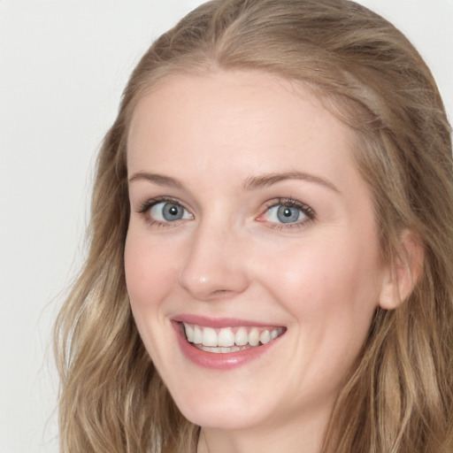 Joyful white young-adult female with long  brown hair and blue eyes