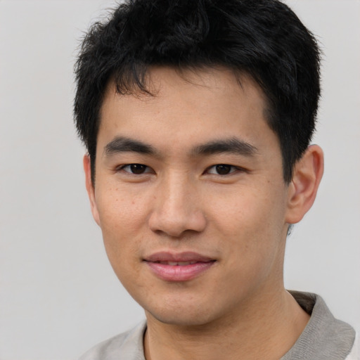 Joyful asian young-adult male with short  black hair and brown eyes