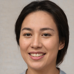 Joyful asian young-adult female with medium  brown hair and brown eyes