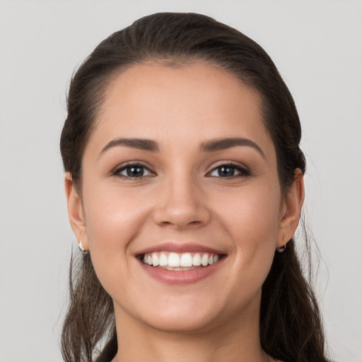 Joyful white young-adult female with long  brown hair and brown eyes