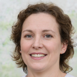 Joyful white adult female with medium  brown hair and grey eyes