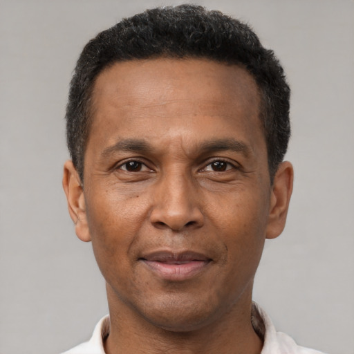 Joyful latino adult male with short  brown hair and brown eyes