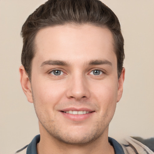 Joyful white young-adult male with short  brown hair and grey eyes