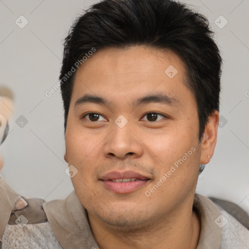 Joyful asian young-adult male with short  brown hair and brown eyes
