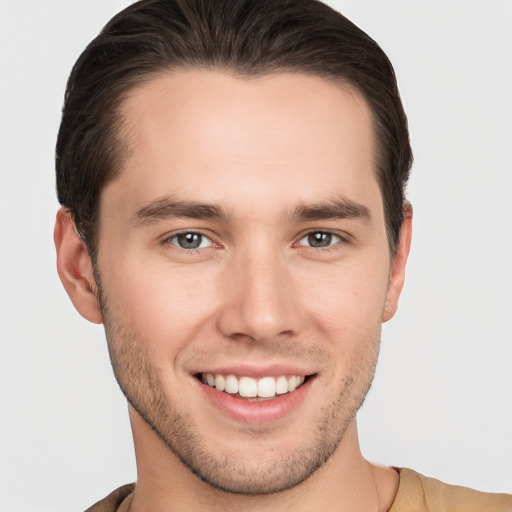 Joyful white young-adult male with short  brown hair and grey eyes