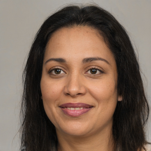 Joyful latino adult female with long  brown hair and brown eyes