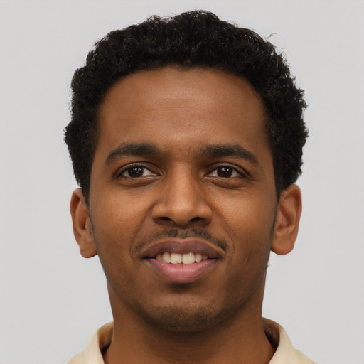 Joyful black young-adult male with short  brown hair and brown eyes