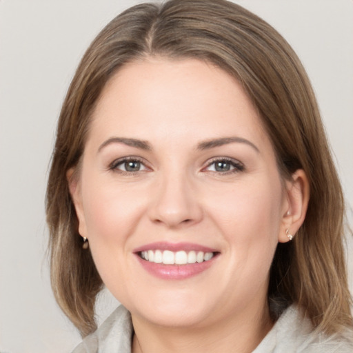 Joyful white young-adult female with medium  brown hair and grey eyes