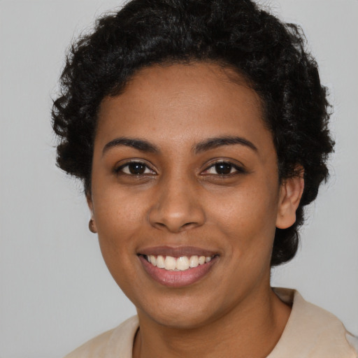Joyful black young-adult female with short  black hair and brown eyes