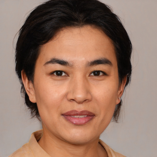 Joyful asian adult female with medium  brown hair and brown eyes