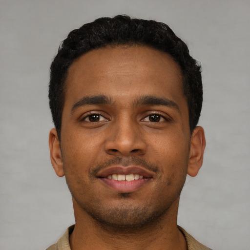 Joyful black young-adult male with short  black hair and brown eyes