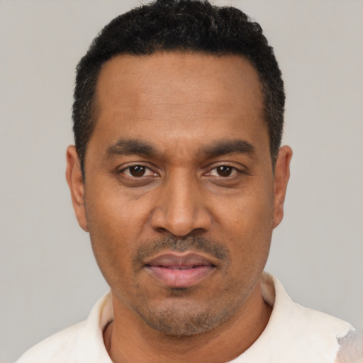 Joyful latino adult male with short  black hair and brown eyes