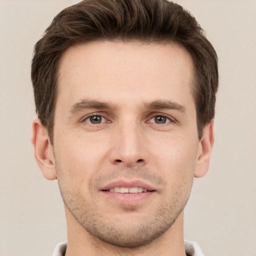 Joyful white young-adult male with short  brown hair and grey eyes