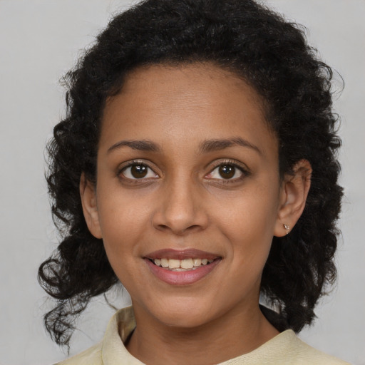 Joyful black young-adult female with medium  brown hair and brown eyes