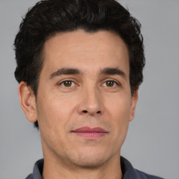 Joyful white adult male with short  black hair and brown eyes