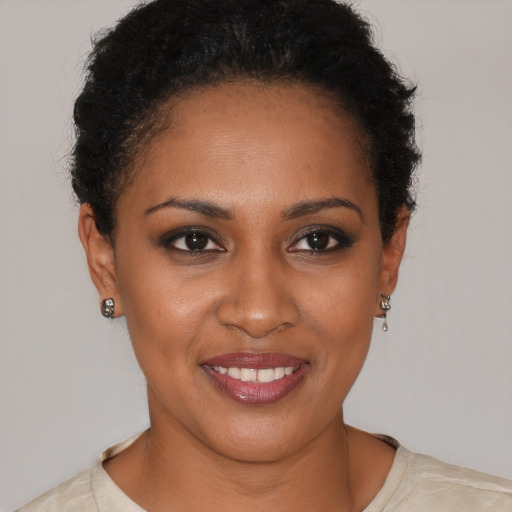 Joyful black young-adult female with short  brown hair and brown eyes