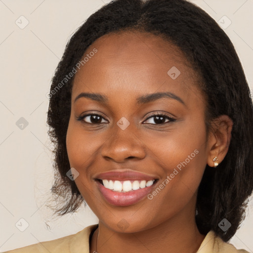 Joyful black young-adult female with long  brown hair and brown eyes