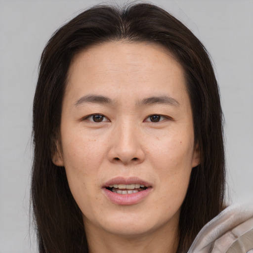 Joyful asian young-adult female with long  brown hair and brown eyes