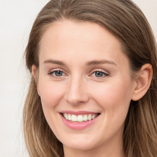 Joyful white young-adult female with long  brown hair and grey eyes