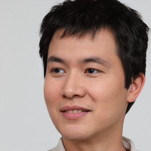Joyful asian young-adult male with short  black hair and brown eyes