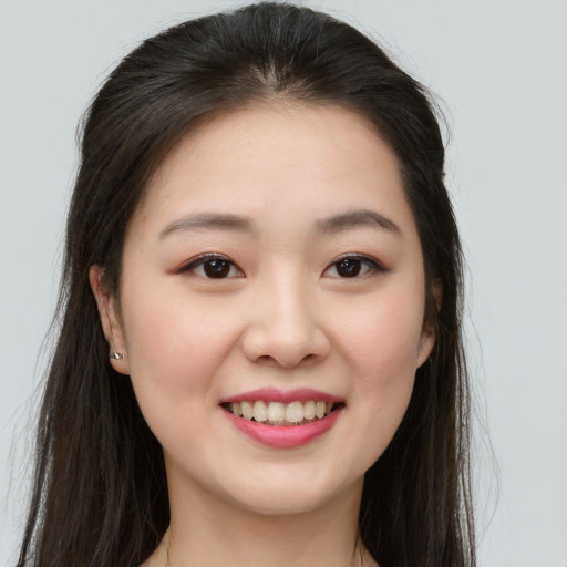 Joyful asian young-adult female with long  brown hair and brown eyes