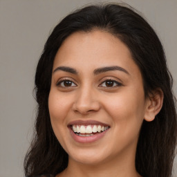 Joyful latino young-adult female with long  brown hair and brown eyes