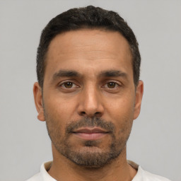 Neutral latino adult male with short  black hair and brown eyes