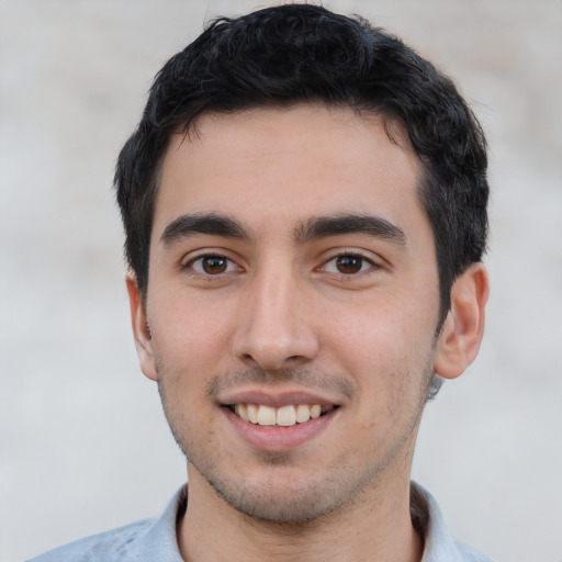 Joyful white young-adult male with short  black hair and brown eyes