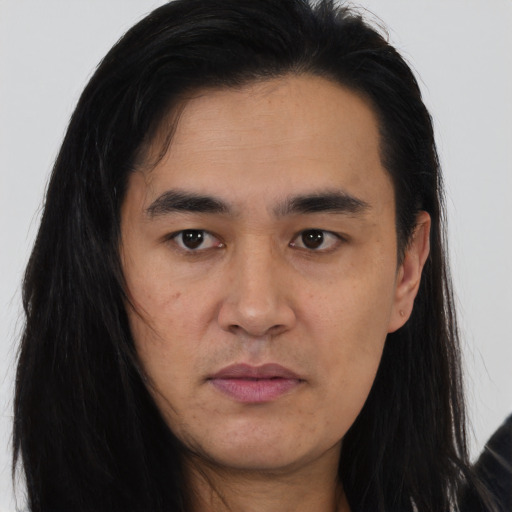 Joyful asian young-adult male with long  brown hair and brown eyes