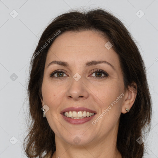 Joyful white adult female with long  brown hair and brown eyes